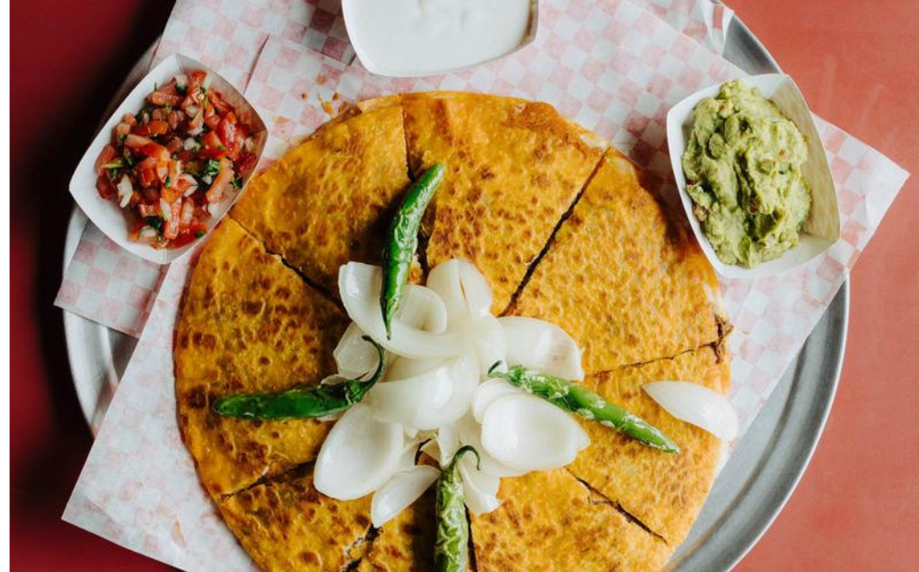 Pizza Birria with melted cheese, guacamole, pico de gallo and consommé