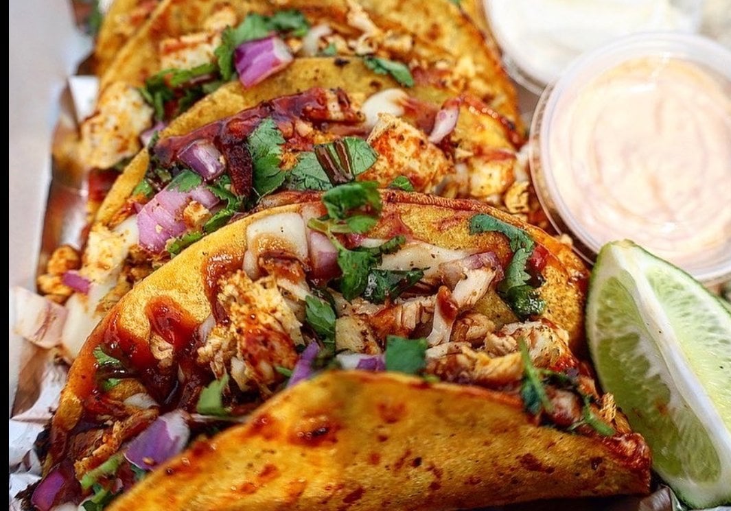 Plate of four assorted tacos with steak, chicken and shrimp