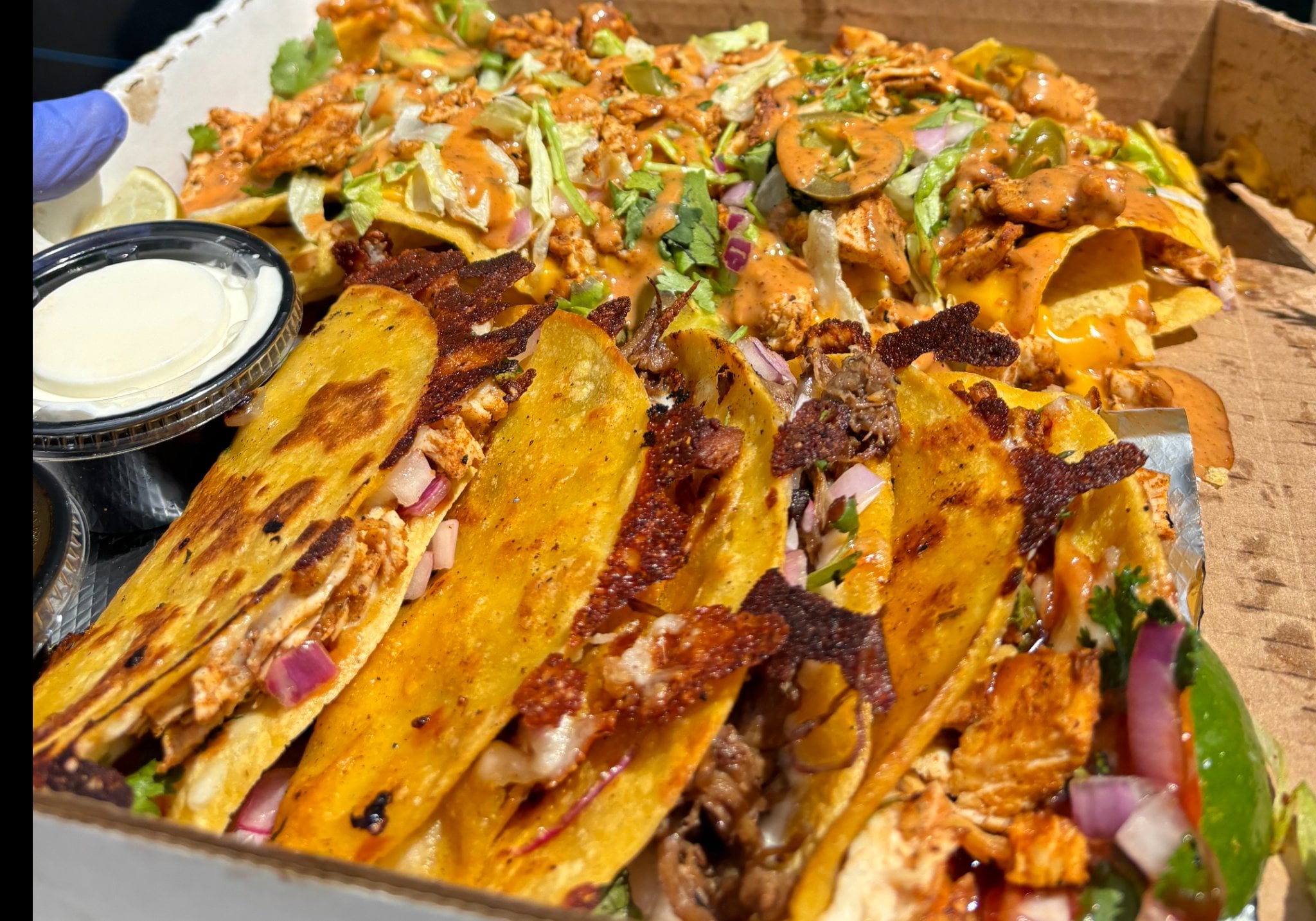 Nacho and taco combo box with four tacos and a half order of nachos