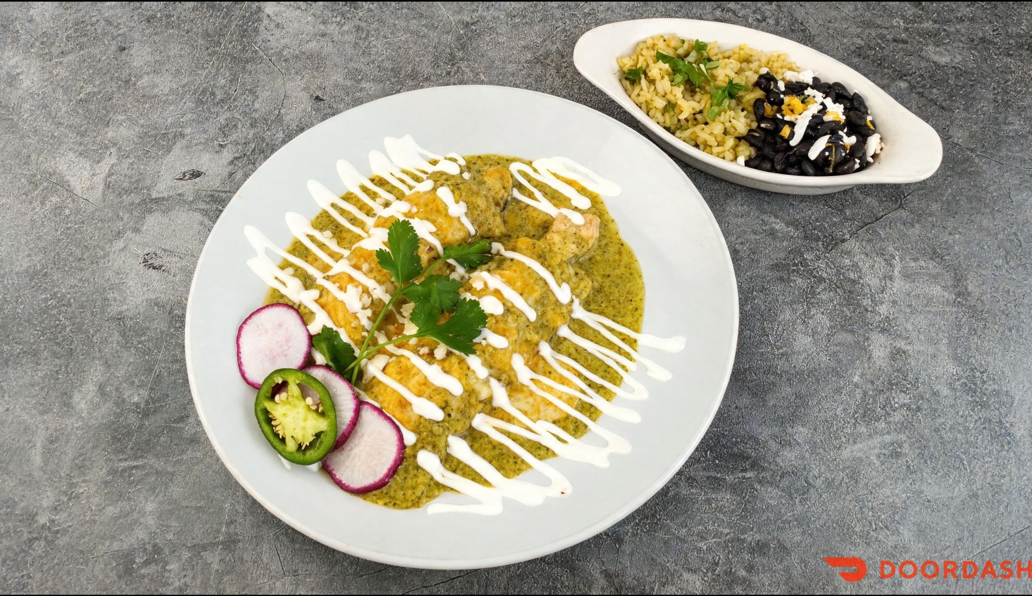 Enchiladas Suizas topped with homemade green tomatillo sauce and sour cream
