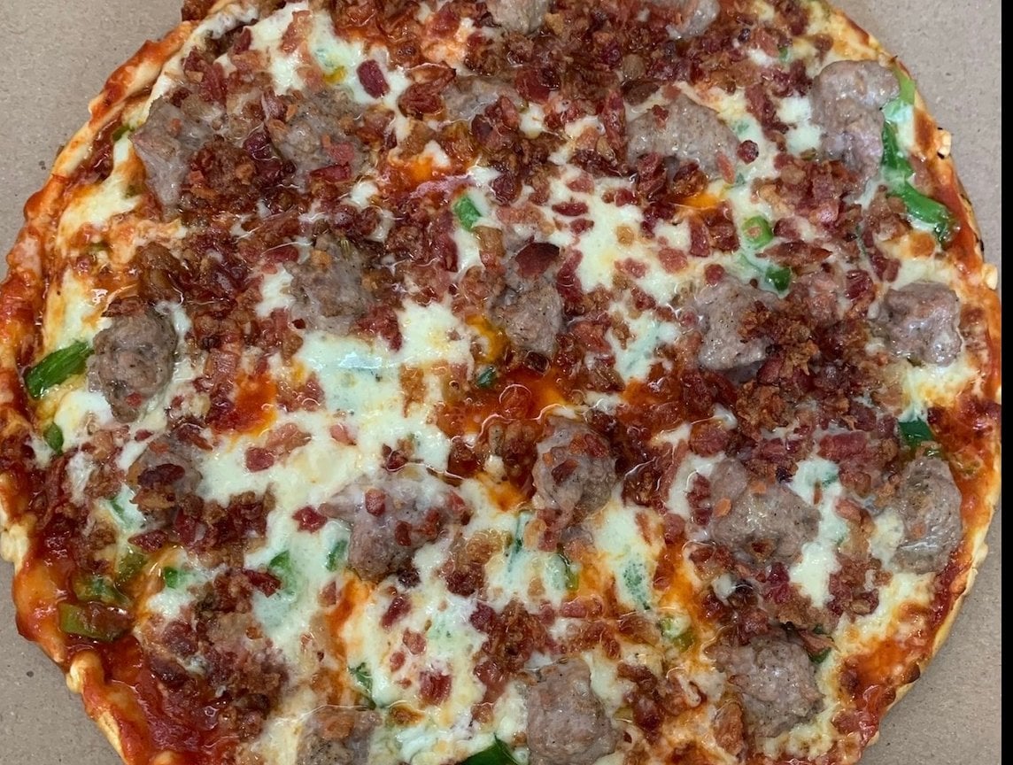 Elvira supreme pizza loaded with meats and vegetables